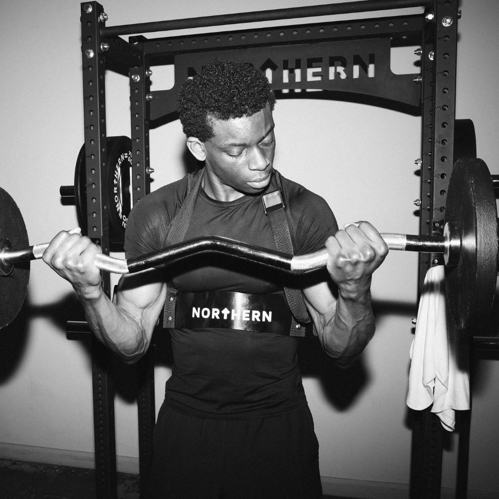 Performing bicep curl using EZ curl bar loaded with cast iron weight plates