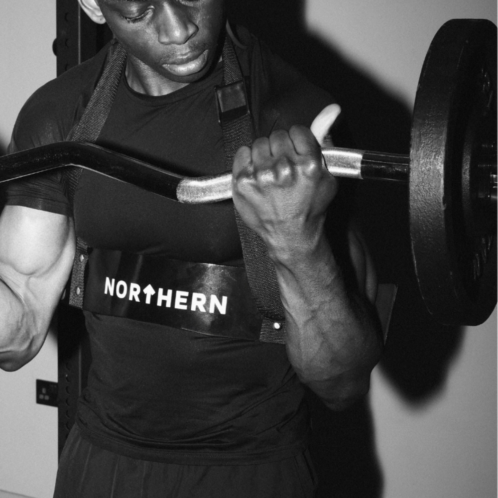 Bicep curl workout using EZ curl bar loaded with classic cast iron plates