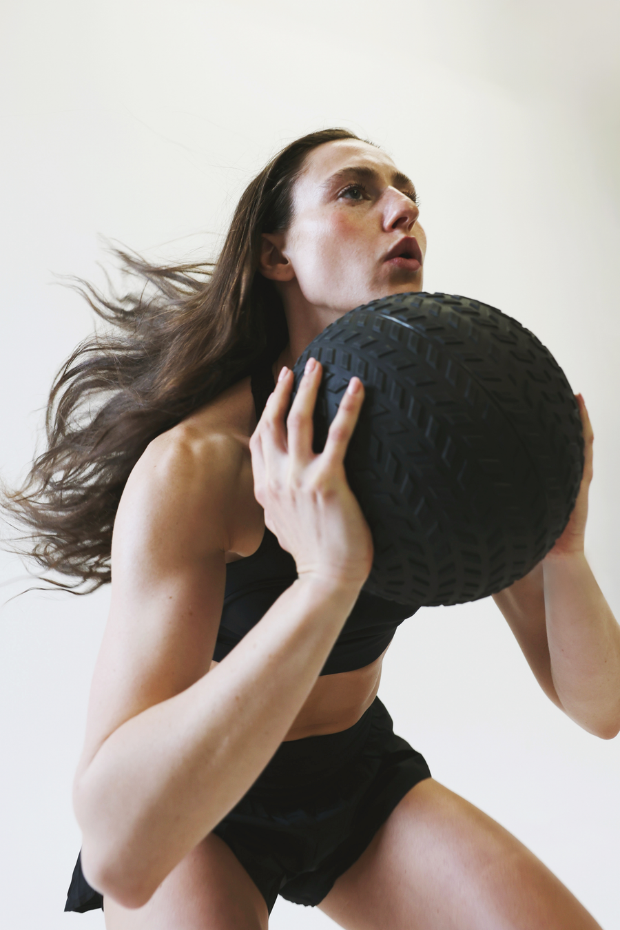 Woman performing over-the-shoulder throw exercise using Northern heavy duty slam ball
