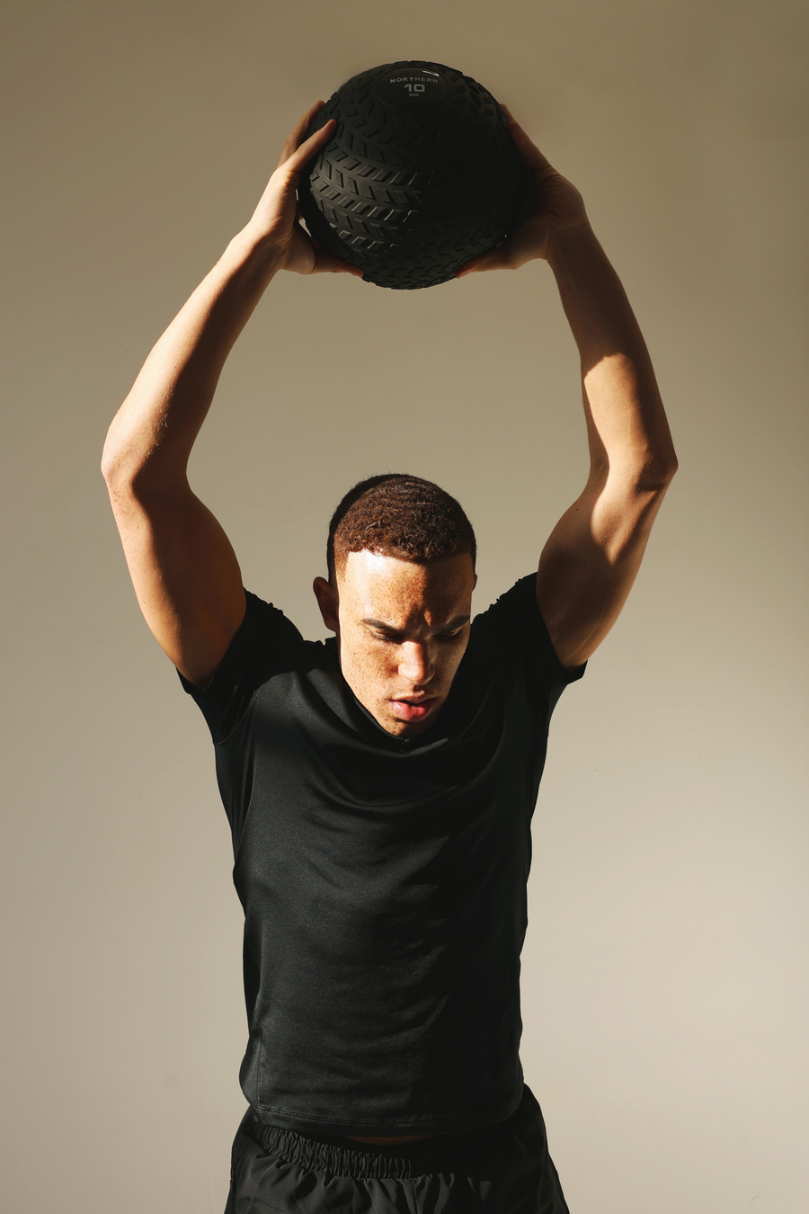 Performing overhead slam workout using Northern slam balls in home gym
