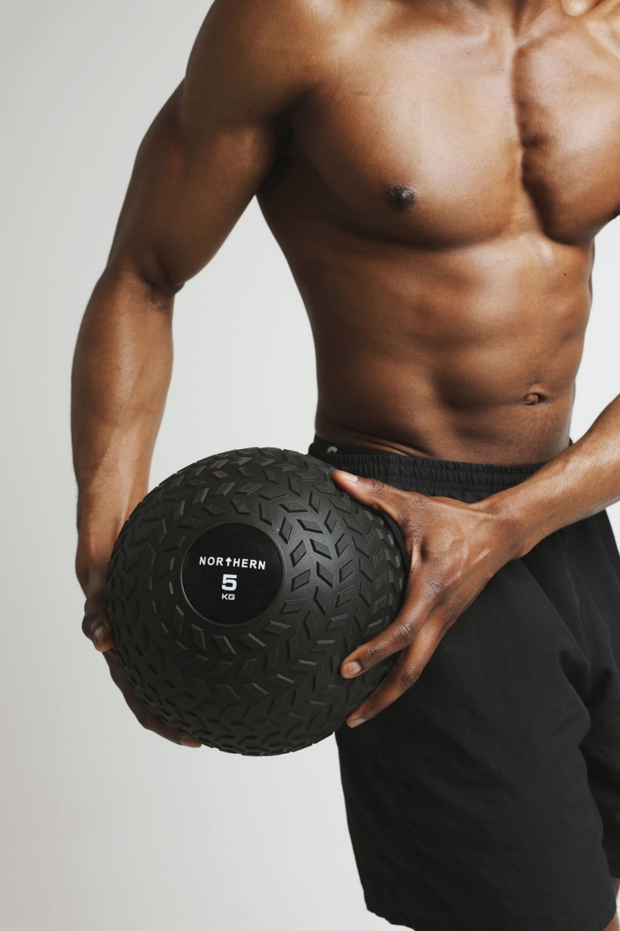 Gripping Northern tyre tread slam balls during standing rotational twist workout